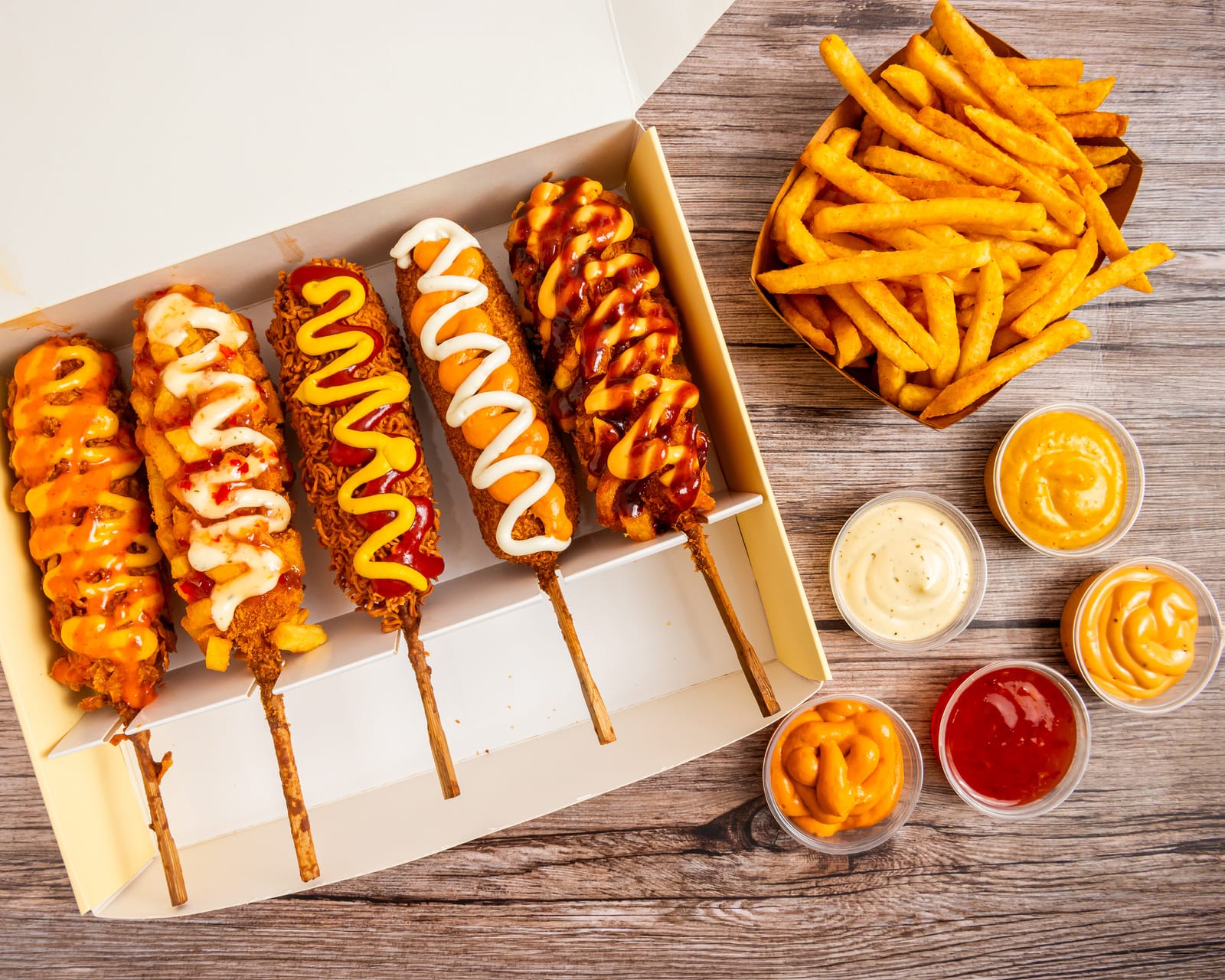 Fünf Corndawgs in der Box, dazu Pommes und Saucen